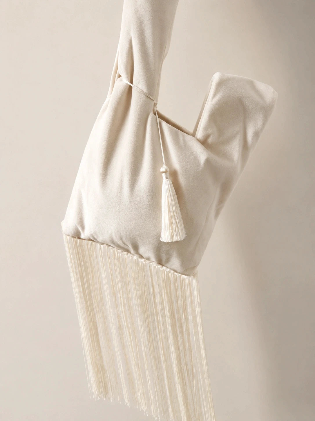 Japanese knot wrist bag in cream with a fringe trim