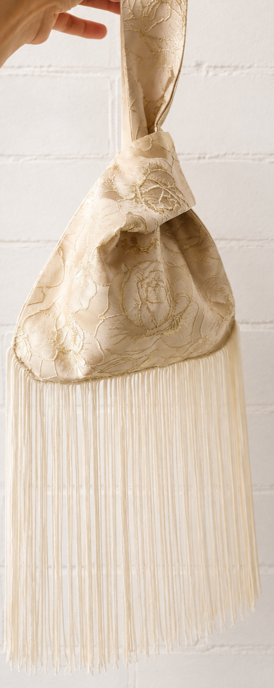 Japanese knot wrist bag in gold with a long fringe trim