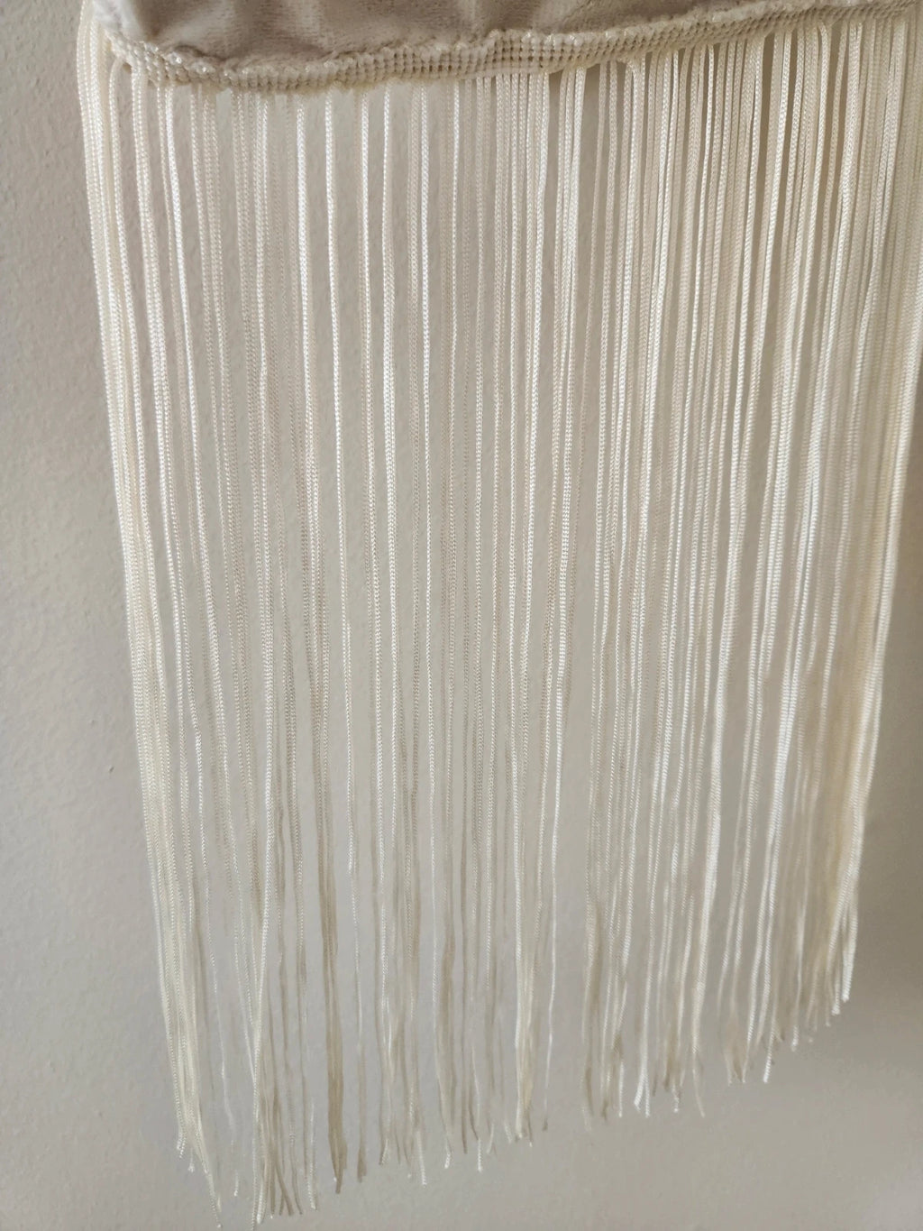 Japanese knot wrist bag in cream with a fringe trim