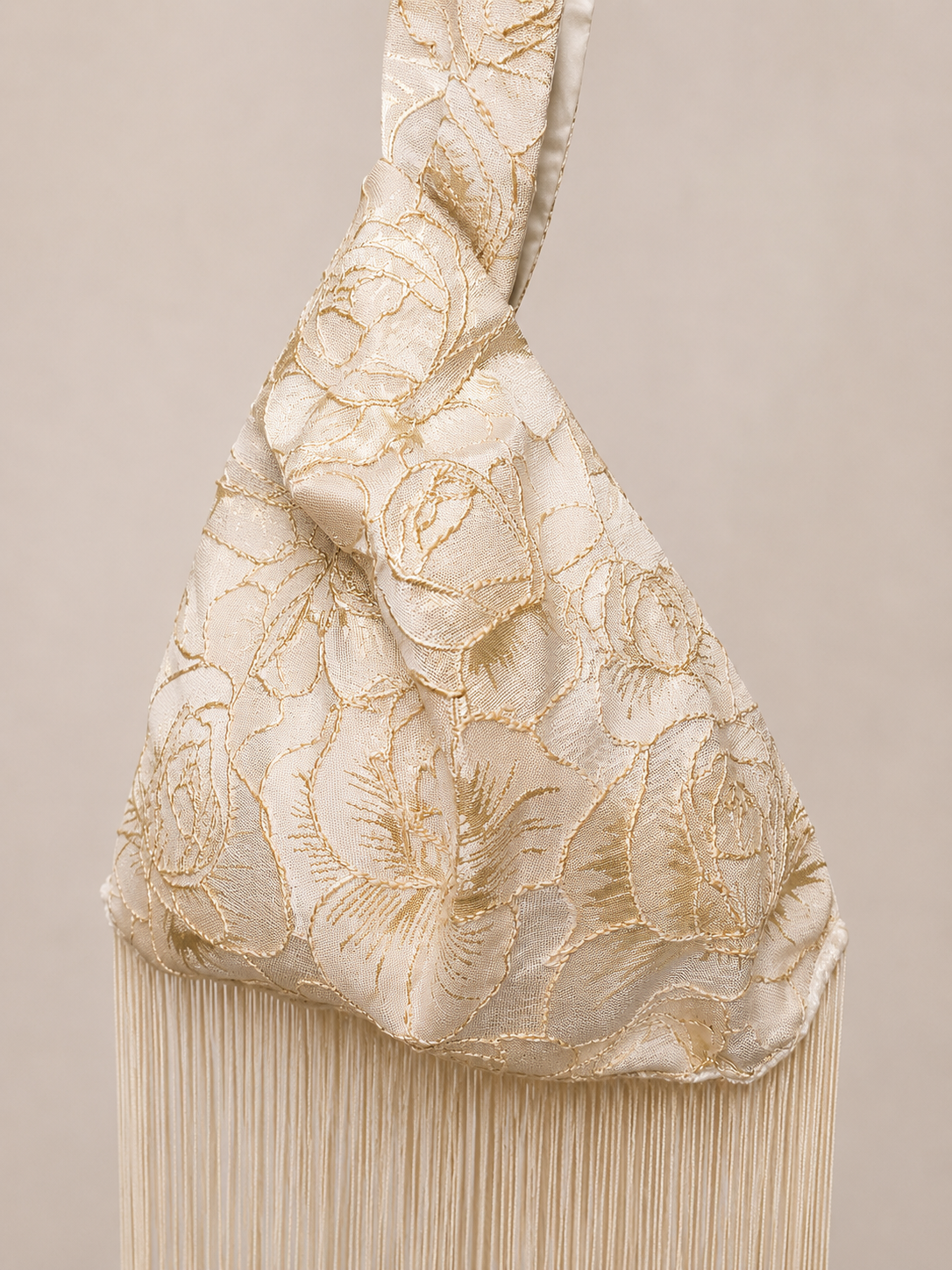 Japanese knot wrist bag in gold with a long fringe trim