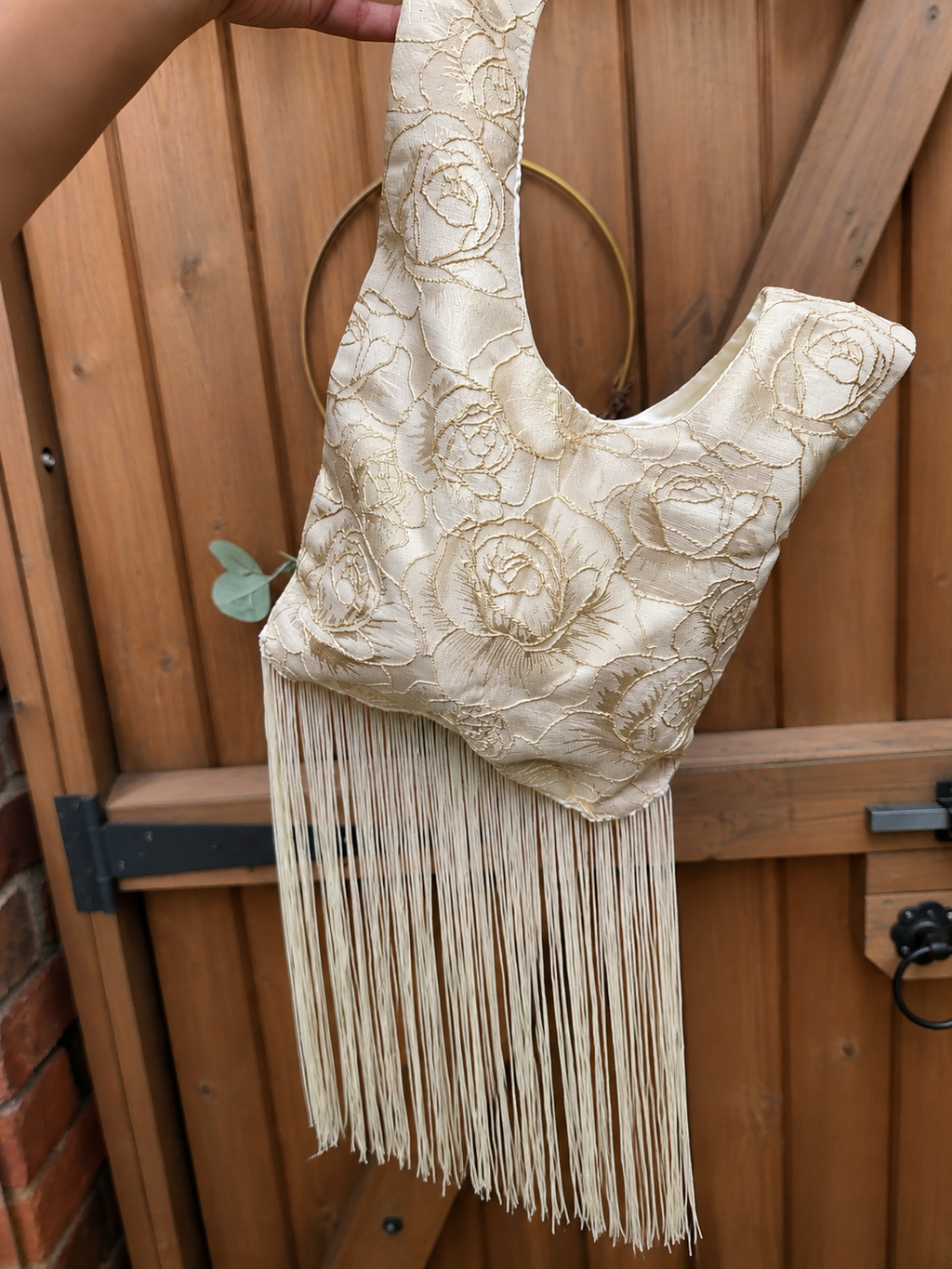 Japanese knot wrist bag in gold with a long fringe trim